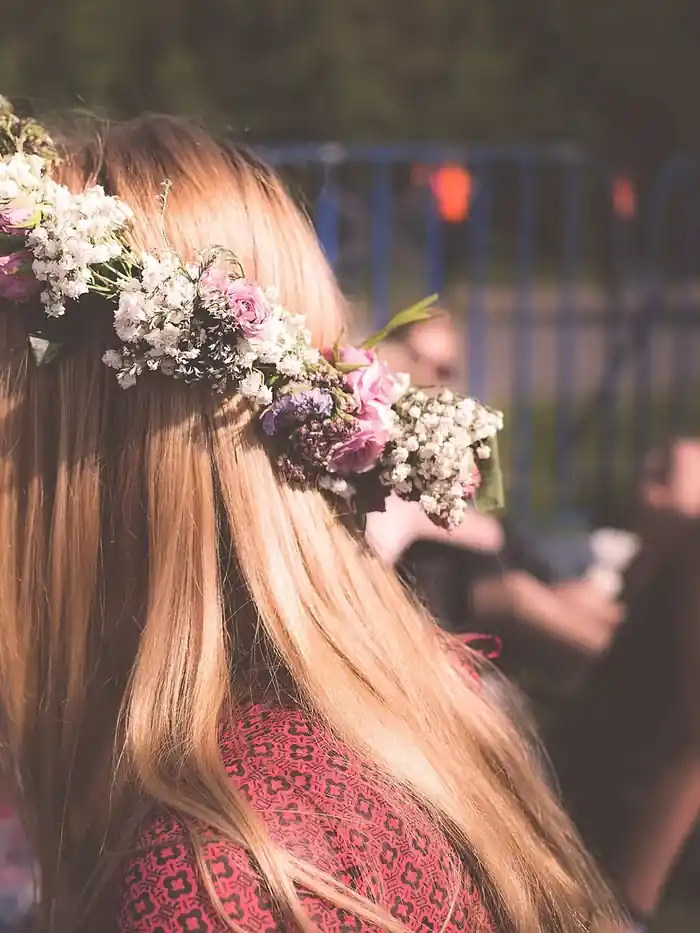 Long fair hair seen from behind, a band of pink roses and baby's breath set across the crown